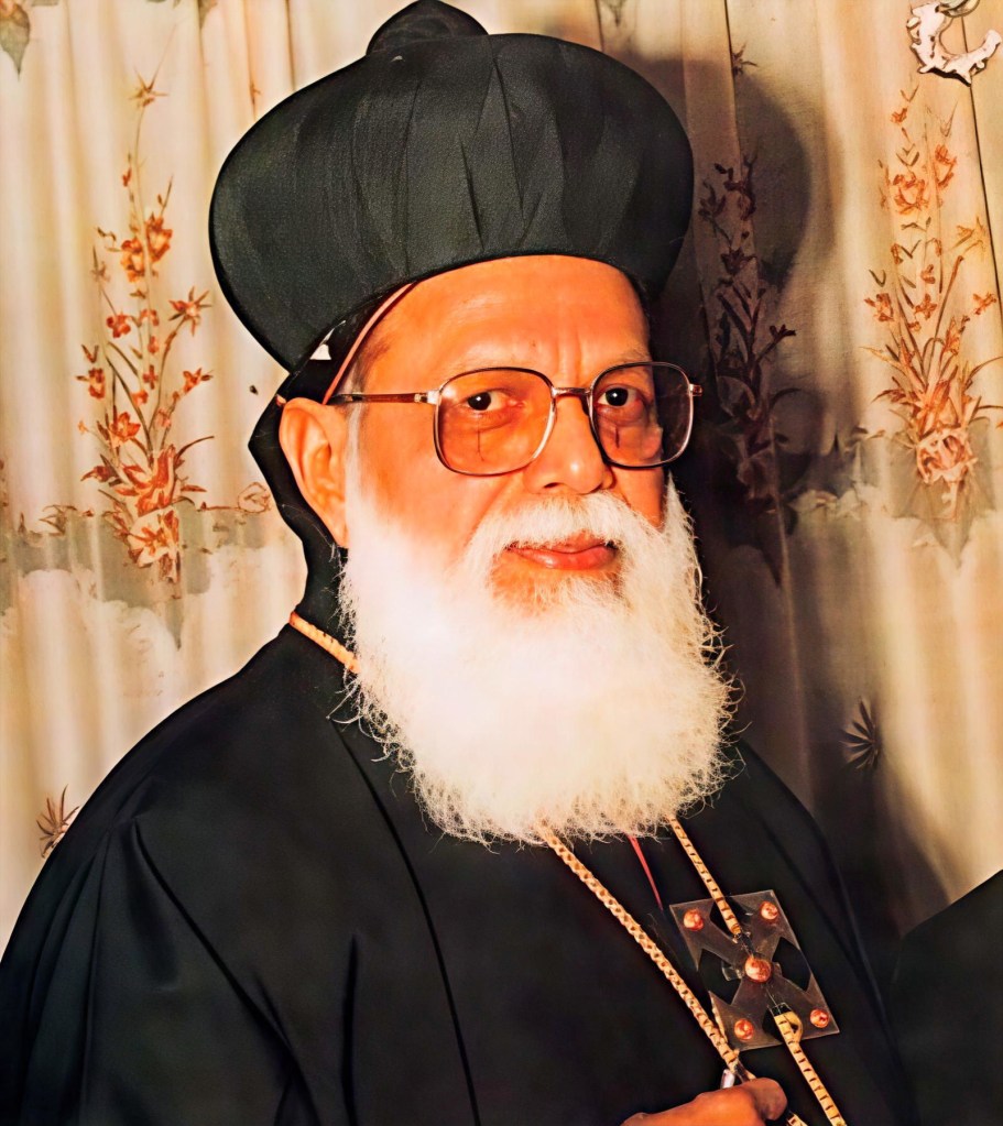 Portrait of Dr. Philipose Mar Theophilos Metropolitan, wearing traditional ecclesiastical attire and a cross, against a floral backdrop.
